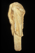 Statue acéphale d’une femme se terminant par un piquet
