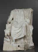 Headless statue of Serapis sitting on the throne 